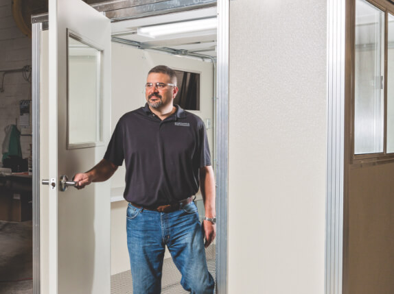 man exiting a smoking booth in a warehouse space