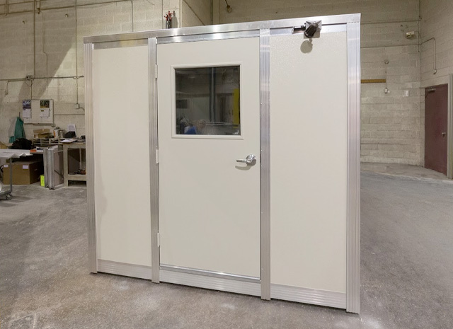 an enclosed, heated booth in a large warehouse space where workers can warm up